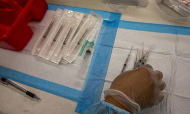 A healthcare worker prepares doses of the Pfizer-BioNTech Covid-19 vaccine at a mobile vaccination clinic at a high school in Los Angeles