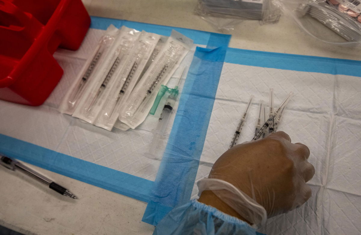 <i>Jill Connelly/Bloomberg/Getty Images</i><br/>A healthcare worker prepares doses of the Pfizer-BioNTech Covid-19 vaccine at a mobile vaccination clinic at a high school in Los Angeles