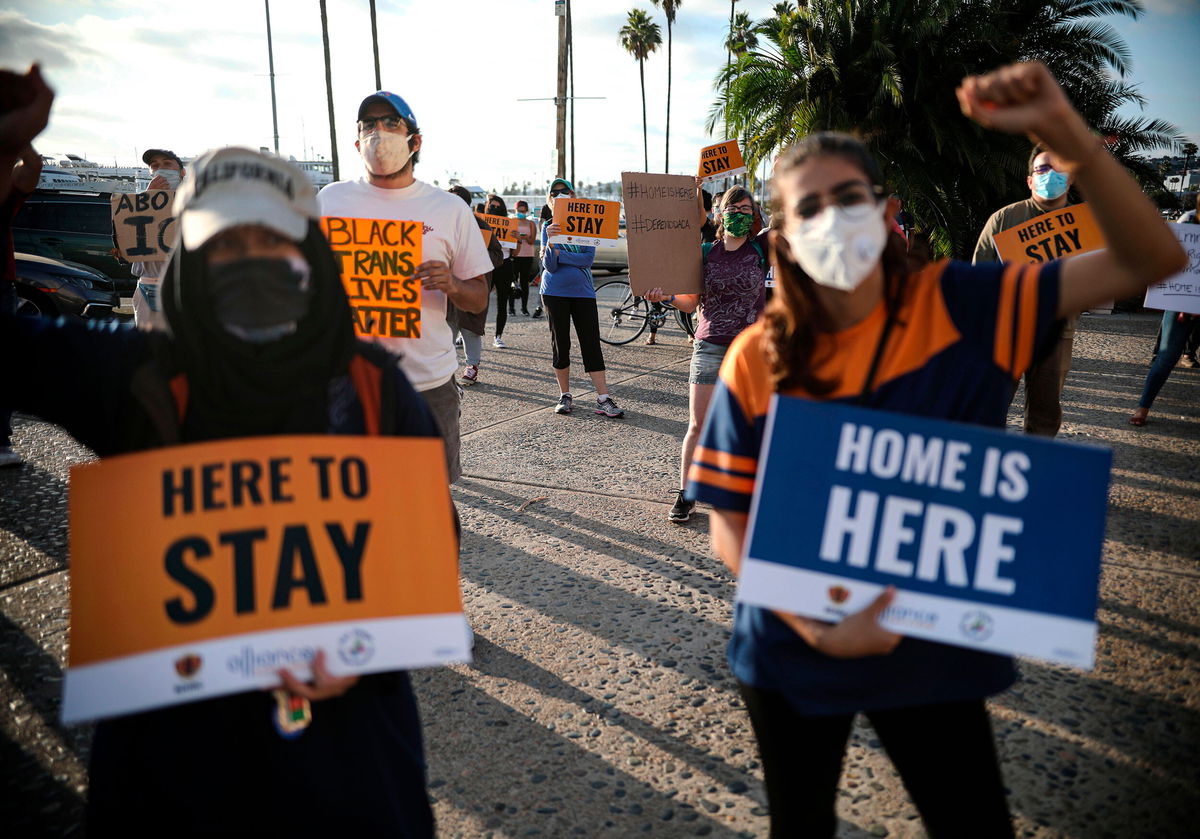 <i>Sandy Huffaker/AFP/Getty Images</i><br/>People hold signs during a rally in support of the Supreme Court's ruling in favor of the Deferred Action for Childhood Arrivals (DACA) program