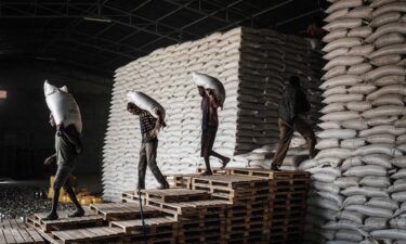 Workers carry sacks of wheat from stocks for food distribution for 4