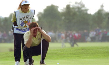 Europe's Faldo and his caddy Sunesson deliberate over a putt.