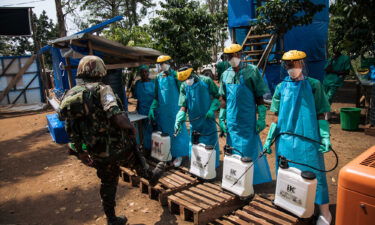 A United Nations peacekeeper has his shoes cleaned with a chlorine solution before leaving an Ebola treatment centre in Mangina