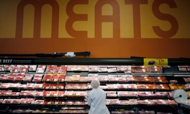 An employee restocks shelves with pork in the meat section at a Kroger Co. supermarket in Louisville