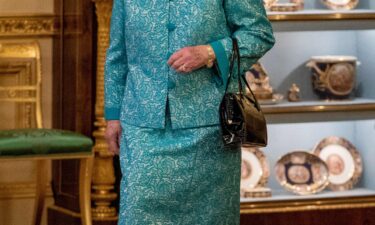 Queen Elizabeth II arrives to greet guests during a reception for international business and investment leaders at Windsor Castle to mark the Global Investment Summit on October 19 in Windsor