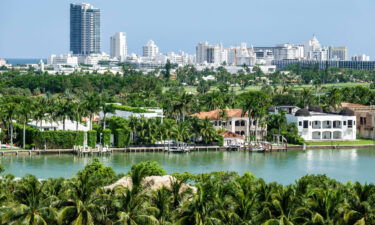 Miami Beach waterfront homes by Biscayne Bay surrounded by palms.