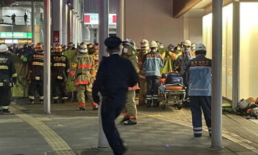 Firefighters and rescue workers gather outside Kokuryo Station on the Keio line in the city of Chofu in western Tokyo on October 31