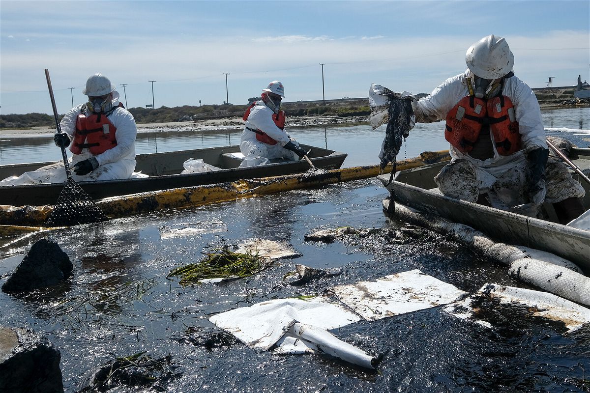 <i>Ringo H.W. Chiu/AP</i><br/>Cleanup contractors deploy skimmers and floating barriers known as booms to try to stop further oil crude incursion into the Wetlands Talbert Marsh in Huntington Beach