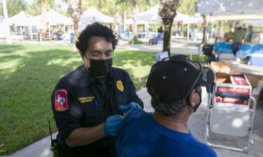 Brownsville Fire Department lieutenant Rodrigo Rangel places a bandage over Homero Ortega's vaccine injection spot at the City of Brownsville's Department of Public Health's popup COVID-19 vaccine clinic