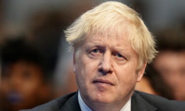 British Prime Minister Boris Johnson listens to Chancellor of the Exchequer Rishi Sunak giving a speech at the Conservative party's conference in Manchester on October 4