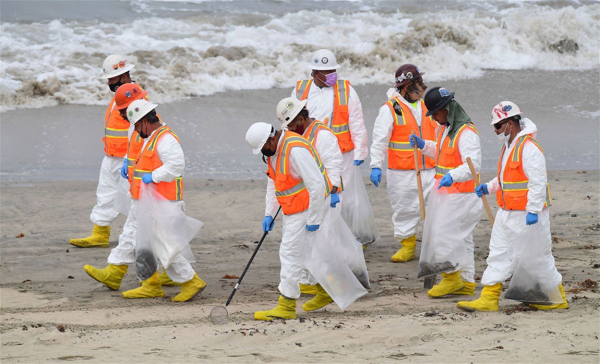 <i>Frederic J. Brown/AFP/Getty Images</i><br/>A cleanup crew works on the beach on Thursday