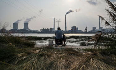 China plans to cut its reliance on fossil fuels to below 20% by 2060. An angler is seen fishing along the Huangpu river across the Wujing Coal-Electricity Power Station in Shanghai on September 28