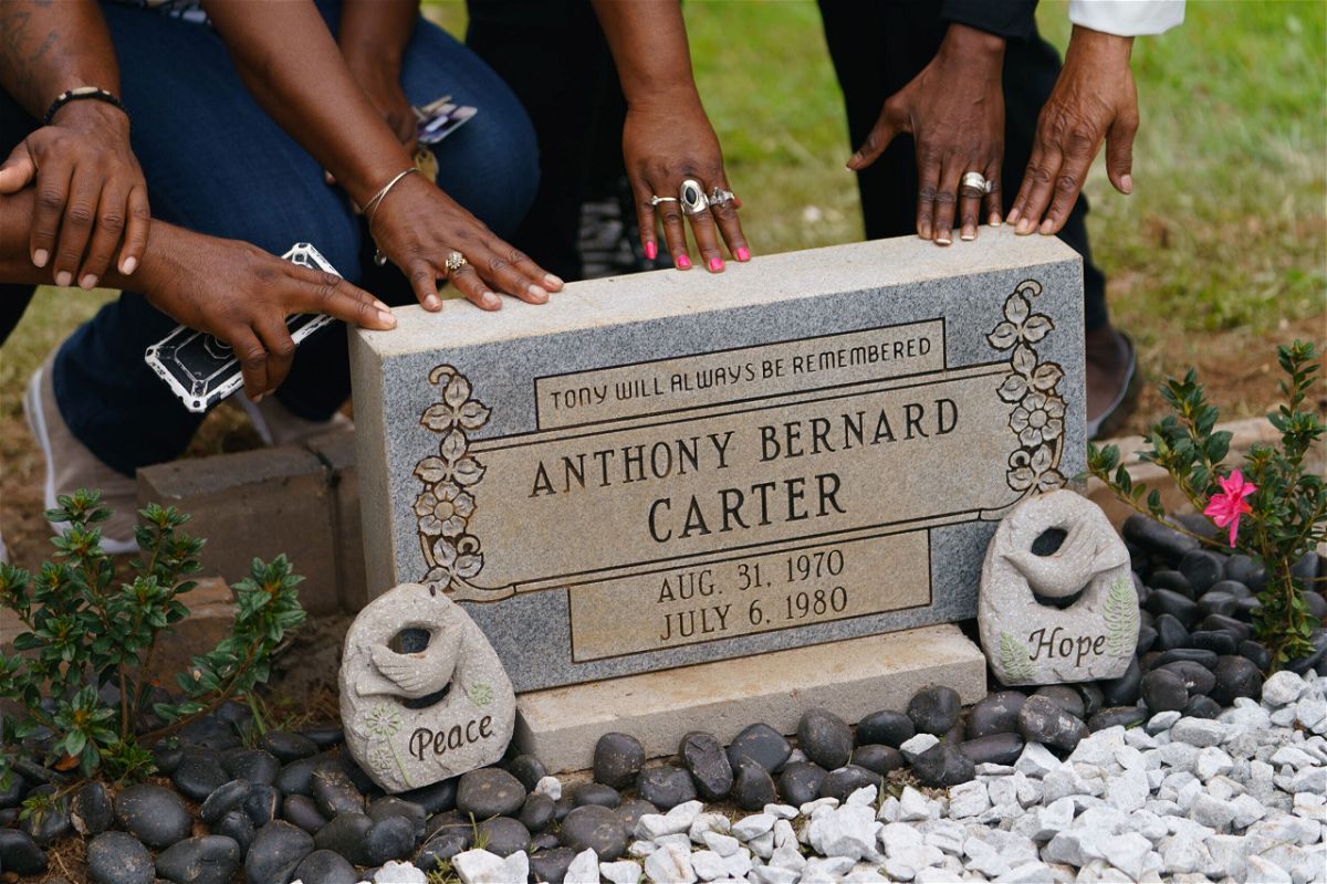 <i>Elijah Nouvelage/Getty Images</i><br/>Family members touch the headstone for Anthony Bernard Carter following its unveiling in Hogansville