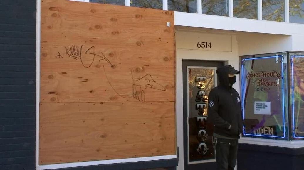 <i>KPTV</i><br/>A board covers a window broken during vandalism at a tatoo shop in Portland