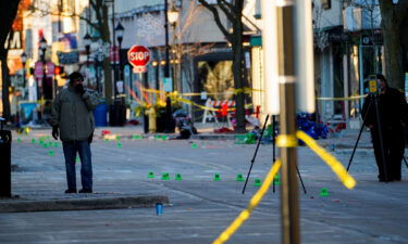 Police officers document marked evidence on Main Street the morning after a vehicle plowed through a holiday parade in Waukesha on Sunday.