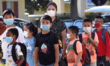 Students are shown here wearing face masks arrive on the first day of classes for the 2021-22 school year at Baldwin Park Elementary School.