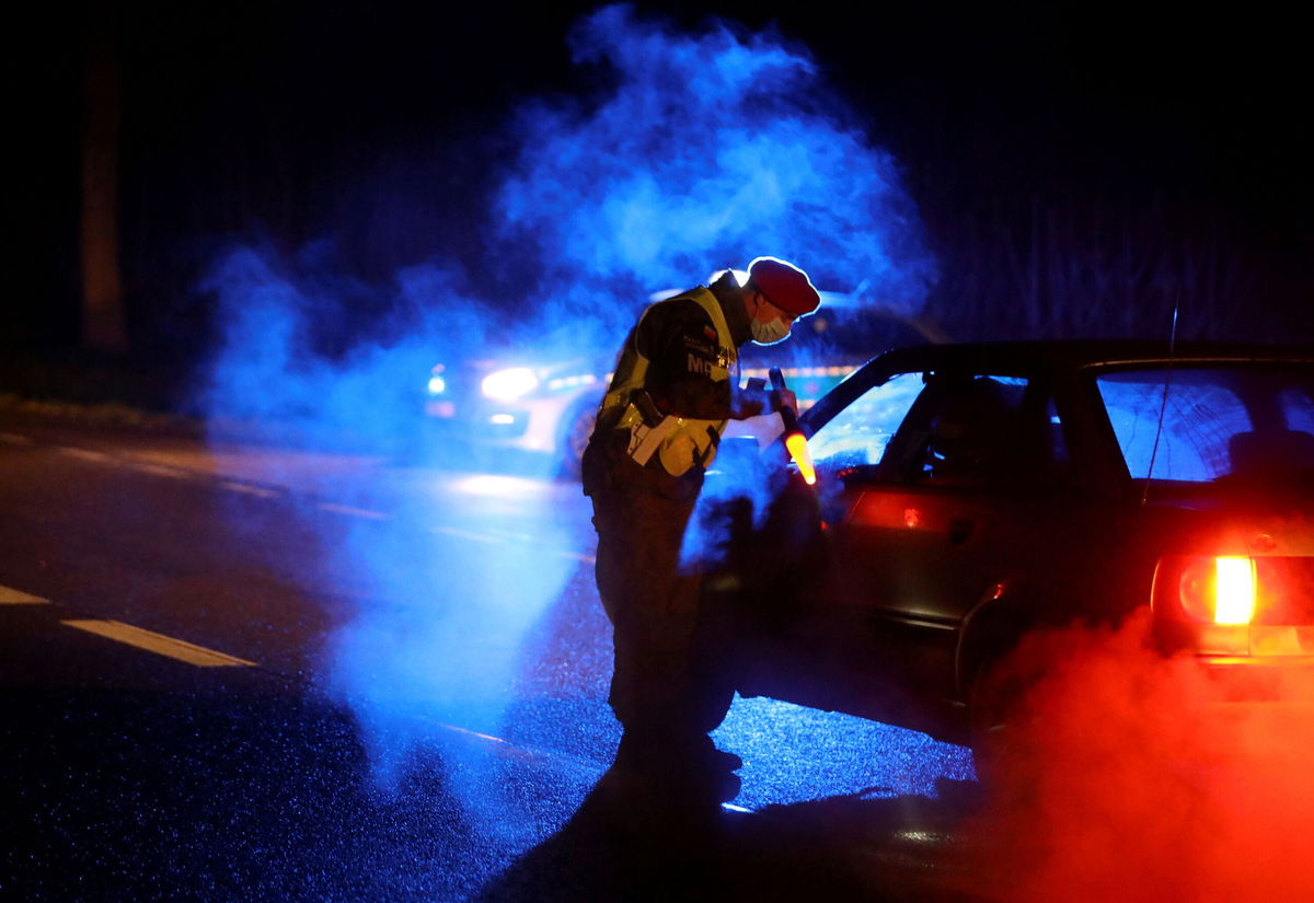 <i>Kacper Pempel/Reuters</i><br/>Military police conduct checks on vehicles near the border on Monday night.