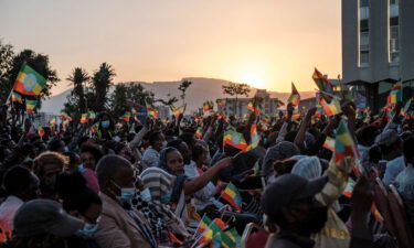 A crowd wave Ethiopian flags during a memorial service for the victims of the Tigray conflict organized by the city administration