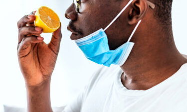 A man tries to smell a lemon