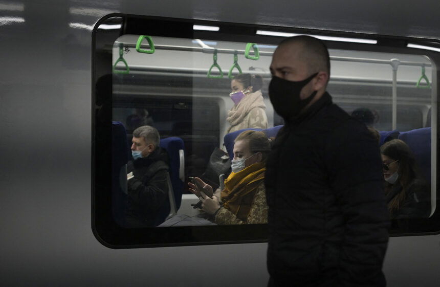 Commuters wearing face masks amid the ongoing Covid-19 pandemic ride on a metro train on October 25