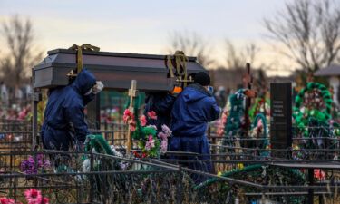 Gravediggers carry a coffin of a Covid-19 victim at the Novo-Yuzhnoye cemetery