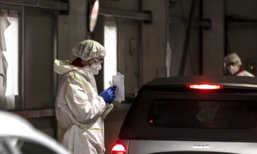 A health worker collects swab sample from a person at a COVID-19 testing station on November 08 in Innsbruck