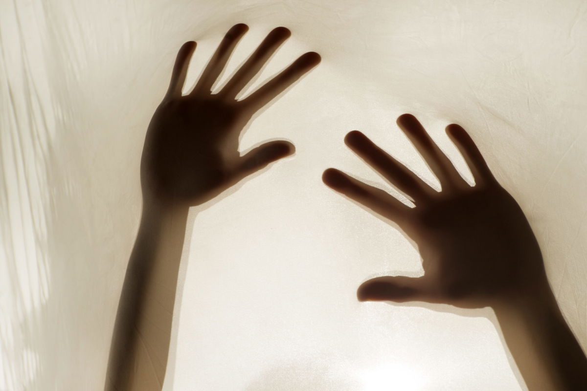 Photographic representation of violence on women, hands against sheet