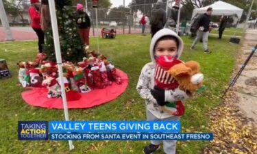 A young child holds a stocking stuffed with goodies at an event sponsored by Friends.giving