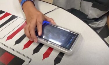 An inmate at the Dallas County Jail holds a computer tablet. The tablets offer the incarcerated population access to digital communication and media services