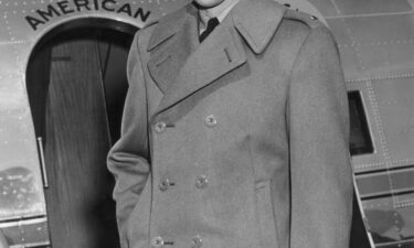 Stewart in the early 1940s with his Air Force cap in front of a military plane.