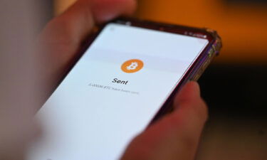 A person uses a cell phone to pay with Bitcoins during the Latin Bitcoin conference (LABITCONF) in San Salvador