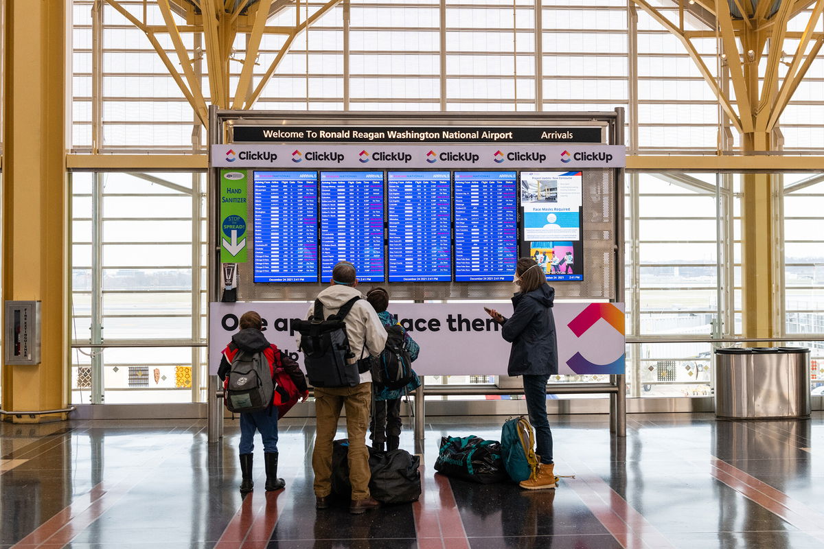 <i>Eric Lee/Bloomberg/Getty Images</i><br/>A family looks at flight information at Reagan National Airport in Arlington