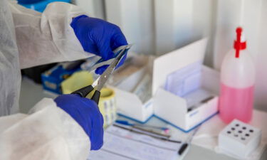 A health worker opens packaging for testing material at a Testaro Covid-19 mobile testing site outside Richmond Corner shopping centre in the Milnerton district of Cape Town