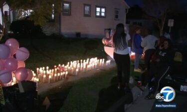 Mourners stand near a memorial for four people who were killed at a birthday party in Inglewood