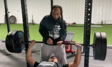 Carlos Williams assists a weightlifter at the gym he co-owns in South Houston