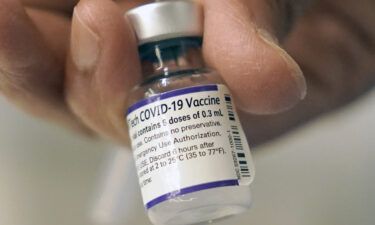 A doctor loads a dose of Pfizer Covid-19 vaccine into a syringe