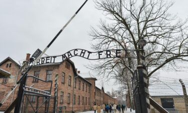 The woman was posing for photos in front of this gate at Auschwitz-Birkenau.