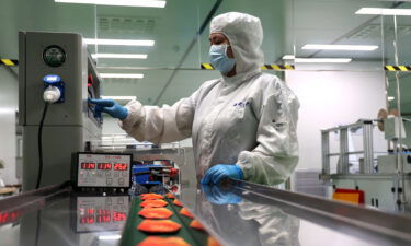 Coronavirus lockdowns are still taking a toll on China's factories. A woman here works on the production line of facial masks in Binzhou in east China's Shandong province Thursday