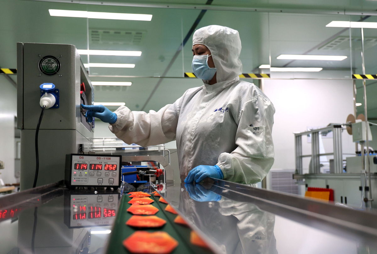 <i>Chu Baoru/Future Publishing/Getty Images</i><br/>Coronavirus lockdowns are still taking a toll on China's factories. A woman here works on the production line of facial masks in Binzhou in east China's Shandong province Thursday