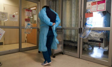 A healthcare worker puts on PPE on the Covid-19 ICU floor of the University of Massachusetts (UMass) Memorial Hospital in Worcester