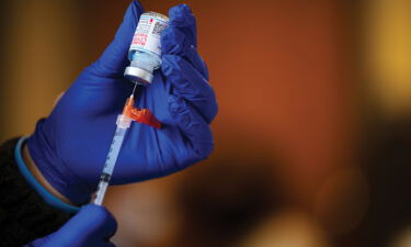 A medical technician fills a syringe from a vial of the Moderna COVID-19 vaccine in Bates Memorial Baptist Church February 12