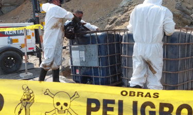 Cleaning crews work to remove oil from a beach in the Peruvian province of Callao on January 19