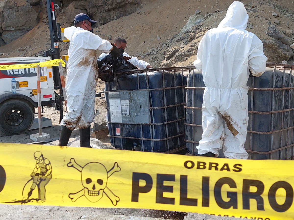 <i>Carlos Mandujano/AFP/Getty Images</i><br/>Cleaning crews work to remove oil from a beach in the Peruvian province of Callao on January 19