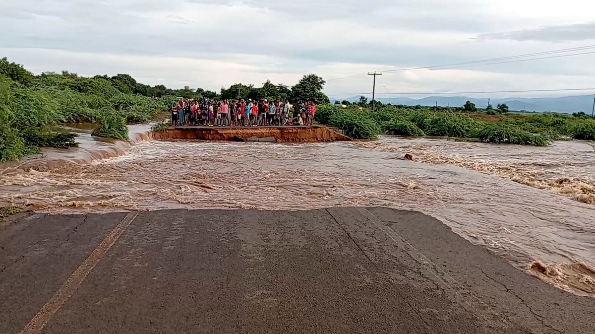 <i>Gerald Nthala/Reuters</i><br/>People stand on the other side of a road destroyed by tropical storm Ana