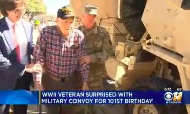 James Neiderer walks to a military supply vehicle with friends and family celebrating his 101st birthday.