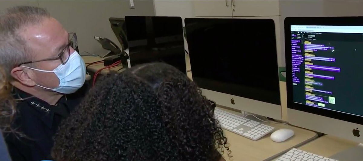 <i>KCAL/KCBS</i><br/>Los Angeles Police Department Chief Michel Moore looks on as a Dorsey High School student explains her project.