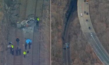 A crumbled BMW lay on train tracks after it  went over a barrier and burst into flames in New York City of February 28