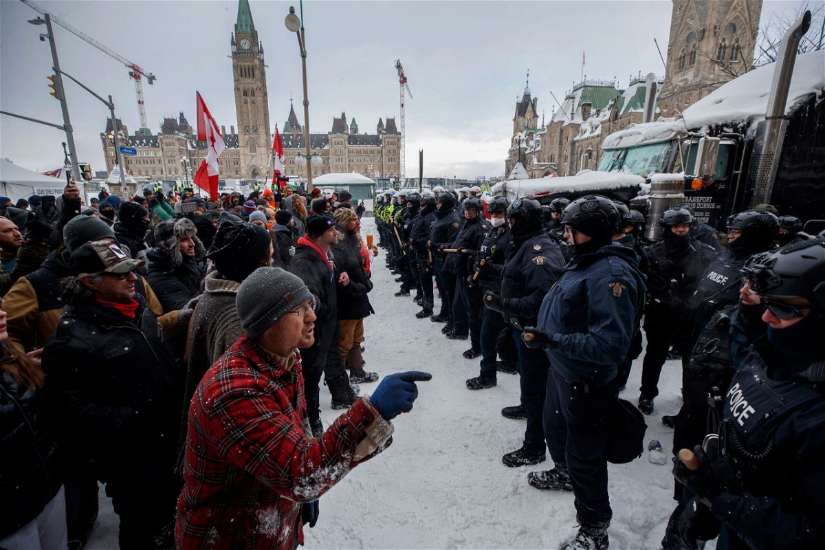 Police move in to clear protesters from downtown Ottawa near Parliament Hill on Saturday, Feb. 19, 2022.  Police resumed pushing back protesters on Saturday after arresting more than 100 and towing away vehicles in Canada’s besieged capital, and scores of trucks left under the pressure, raising authorities’ hopes for an end to the three-week protest against the country’s COVID-19 restrictions. (Cole Burston /The Canadian Press via AP)