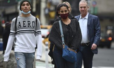 People walking through Herald Square wear protective face masks while others do not outdoors in New York