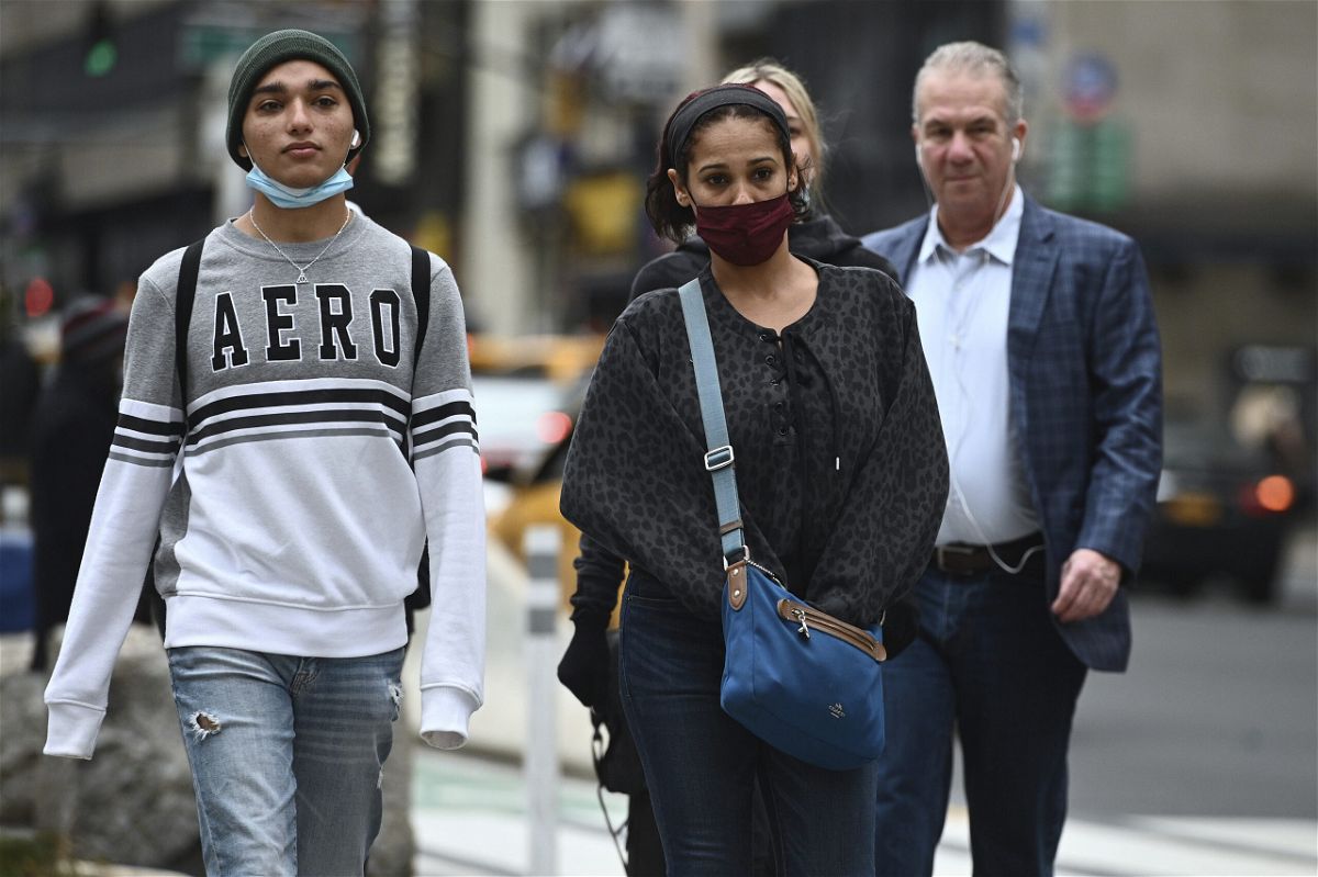 <i>ANTHONY BEHAR//Sipa/AP</i><br/>People walking through Herald Square wear protective face masks while others do not outdoors in New York