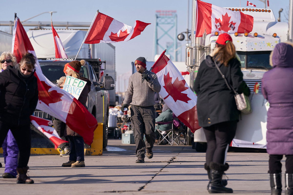 <i>Geoff Robins/AFP/Getty Images</i><br/>Protestors against Covid-19 vaccine mandates block the roadway at the Ambassador Bridge border crossing in Windsor